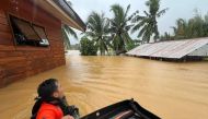 This handout photo taken on November 21, 2023 and received from the Philippine Coast Guard on November 22 shows coast guard personnel wading through floodwaters during evacuation operations at a village in Catarman town, Northern Samar, central Philippines. Photo by Handout / Philippine Coast Guard (PCG) / AFP