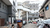 Palestinians gather outside one of the departments of the Al-Shifa hospital complex in Gaza City in the northern Gaza Strip on November 22, 2023. (Photo by Ahikam Seri / AFP)

