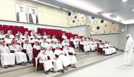 Students listen to an NHRC official at a school. 