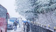 Commuters wait for transport at a bus station during snowfall in Dalian, in China's northeastern Liaoning province on November 23, 2023. Photo by AFP