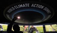An attendee takes photos during a video presentation as part of the Transforming Food Systems in the Face of Climate Change event on the sidelines of the COP28 climate summit at Dubai Expo on December 1, 2023. (Photo by Saul Loeb / POOL / AFP)