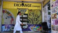 File: A man walks past foreign currency exchange market in Islamabad on July 11, 2023. (Photo by Aamir Qureshi / AFP)