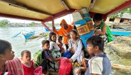 Earthquake-affected residents ride a boat as they evacuate from Hinatuan, Surigao del Sur province on December 3, 2023, following a 7.6 magnitude quake late on December 2. (Photo by AFP)
