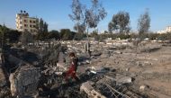 A Palestinian boy collects wood near a cemetery damaged following Israeli air strikes in Rafah in the southern Gaza Strip early on December 4, 2023. (Photo by Mohammed Abed / AFP)
 