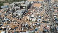 This aerial view taken on December 9, 2023 shows the makeshift tent camps housing Palestinians displaced by intense Israeli bombardment on the Gaza Strip seeking refuge in open areas around the Raed al-Attar Mosque in Rafah in the southern Gaza Strip near the Egyptian border. Photo by SAID KHATIB / AFP