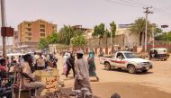 File: Pedestrians and vehicles move along a road outside a branch of the Central Bank of Sudan in the country's eastern city of Gedaref on July 9, 2023. (Photo by AFP)