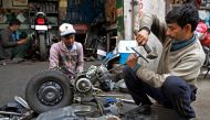 Workers repair a scooter at their workshop in Amritsar on December 12, 2023. (Photo by Narinder NANU / AFP)