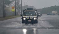 A motorist drives through floodwater as Cyclone Jasper approaches landfall in Cairns in far north Queensland on December 13, 2023. Photo by Brian CASSEY / AFP