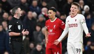 Liverpool's English defender #66 Trent Alexander-Arnold (C) and Manchester United's Scottish midfielder #39 Scott McTominay wait with Referee Michael Oliver for the outcome a VAR review in to a possible Manchester United handball, during the English Premier League football match between Liverpool and Manchester United at Anfield in Liverpool, north west England on December 17, 2023. (Photo by Paul ELLIS / AFP)