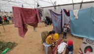 Palestinians, displaced by the Israeli bombardment of Khan Yunis, seek shelter inside an agricultural tent in Rafah in the southern Gaza Strip on December 21, 2023. Photo by MOHAMMED ABED / AFP