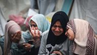 Palestinians mourn their relatives, killed in an overnight Israeli strike on the Al-Maghazi refugee camp, during a mass funeral at the Al-Aqsa hospital in Deir Al-Balah, in the central Gaza Strip, on December 25, 2023. Photo by MAHMUD HAMS / AFP
