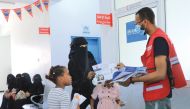 A QRCS representative distributes health awareness materials.