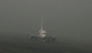 An aircraft prepares to take off amid dense fog on a cold winter morning at Indira Gandhi International Airport in New Delhi on December 27, 2023. (Photo by Arun SANKAR / AFP)