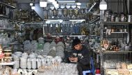 A man use his mobile phone at a household appliances shop in Hanoi on December 29, 2023. Photo by Nhac NGUYEN / AFP