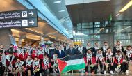 Palestine players and officials pose for a group photo after arriving in Doha. 