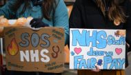 People hold placards calling for fairer pay on a picket line outside Great Ormond Street Children's Hospital in London on April 12, 2023, on the second day of a strike by NHS junior doctors -- physicians who are not senior specialists but who may still years of experience. Photo by Daniel LEAL / AFP