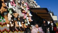 A child walks past a toy shop converted from a trailer along a business street in Beijing on January 3, 2024. (Photo by WANG Zhao / AFP)
