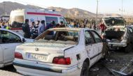 This photograph taken on January 3, 2024 shows destroyed cars and emergency services near the site where two explosions in quick succession struck a crowd marking the anniversary of the 2020 killing of Guards general Qasem Soleimani, near the Saheb al-Zaman Mosque in the southern Iranian city of Kerman. (Photo by TASNIM NEWS / AFP)
