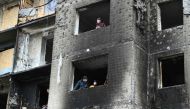 Local residents look from windows of a heavily damaged residential building, three days after a Russian missile attack in Kyiv, on January 5, 2024. (Photo by Genya Savilov / AFP)
 