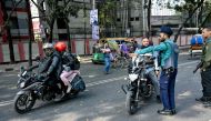 Police personnel inspect vehicles at a checkpoint near a polling station during Bangladesh's general elections in Dhaka on January 7, 2024. (Photo by Indranil Mukherjee / AFP)
