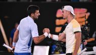 Serbia's Novak Djokovic (L) greets Croatia's Dino Prizmic after beating him in their men's singles match on day one of the Australian Open tennis tournament in Melbourne on January 14, 2024. (Photo by WILLIAM WEST / AFP)