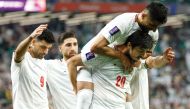 Sardar Azmoun celebrates with teammates after scoring Iran's fourth goal against Palestine. AFP