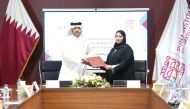 Executive Director of the Administrative and Financial Division at the DI Eman bin Abdulla Alsulaiti (right) and Vice-Chairman of Seashore Group Saqr Saeed Almohannadi exchanging documents after signing the agreement.