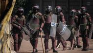(FILES) Kenyan Police officers watch protesters as they block the street during a mass rally called by the opposition leader Raila Odinga who claims the last Kenyan presidential election was stolen from him and blames the government for the hike of living costs in Kibera, Nairobi on March 27, 2023. (Photo by YASUYOSHI CHIBA / AFP)
