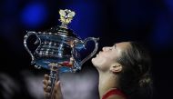 Belarus' Aryna Sabalenka kisses the Daphne Akhurst Memorial Cup after victory against China's Zheng Qinwen during their women's singles final match on day 14 of the Australian Open tennis tournament in Melbourne on January 27, 2024. (Photo by Lillian SUWANRUMPHA / AFP)