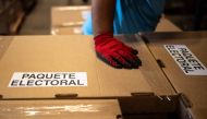 An employee of the Supreme Electoral Tribunal (TSE) loads boxes containing electoral material for the presidential and legislative elections to be distributed in the different municipalities of the capital at the Electoral Organization Directorate in San Marcos, El Salvador, on February 2, 2024. El Salvador goes to the polls on February 4. (Photo by Yuri CORTEZ / AFP)
