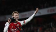 Arsenal's Norwegian midfielder #08 Martin Odegaard picks up a camera and takes pictures as he celebrates at the end of the English Premier League football match between Arsenal and Liverpool at the Emirates Stadium in London on February 4, 2024. (Photo by Ian Kington / IKIMAGES / AFP)