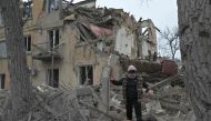 A woman walks among debris of a residential building partially destroyed by a missile attack in the town of Selydove, Donetsk region, on February 8, 2024, amid the Russian invasion of Ukraine. (Photo by Genya Savilov / AFP)
