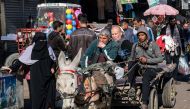 A youth drives a donkey-drawn cart along a crowded main street in Rafah in the southern Gaza Strip yesterday.  (AFP)