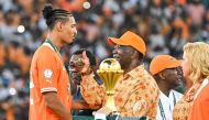 President of Ivory Coast Alassane Ouattara (C) congratulates Ivory Coast's forward #22 Sebastien Haller (L) after winning at the end of the Africa Cup of Nations (CAN) 2024 final football match between Ivory Coast and Nigeria at Alassane Ouattara Olympic Stadium in Ebimpe, Abidjan on February 11, 2024. (Photo by Sia Kambou / AFP)