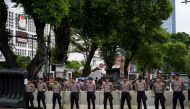 Police secure a road as a group of people supporting presidential candidate Anies Baswedan takes part in a rally in front of the General Election Commission (KPU) in Jakarta on February 16 2024, and demand that the KPU reveal fraud committed by presidential candidate Prabowo Subianto, who also won the quick count version of the presidential election and was supported by incumbent President Joko Widodo. (Photo by BAY ISMOYO / AFP)
