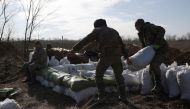 Ukrainian servicemen pile up earthbags to build a fortification not far from town of Avdiivka in the Donetsk region, amid the Russian invasion of Ukraine, on February 17, 2024. (Photo by Anatolii STEPANOV / AFP)
