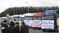 Ukrainian truck drivers take part in a protest against the blockade of the border by the Polish protesters at the Rava-Ruska border crossing point of the Ukrainian-Polish border, with trucks bannered with messages and Ukrainian flags on February 20, 2024, amid the Russian invasion of Ukraine. (Photo by YURIY DYACHYSHYN / AFP)
