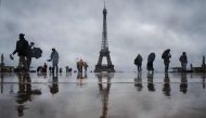 Visitors walk at the Esplanade du Trocadero with the Eiffel Tower in the background, which is closed to the public on the fourth day of its staff's strike, in Paris on February 22, 2024. (Photo by Dimitar Dilkoff / AFP)