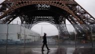 A pedestrian walks past the Eiffel Tower, which is closed to the public on the fourth day of its staff's strike, in Paris on February 22, 2024. (Photo by Dimitar DILKOFF / AFP)
