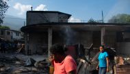 A woman cries as she walks near her husband's shop that armed gang members set fire to in Port-au-Prince, Haiti, March 7, 2024. (Photo by clarens SIFFROY / AFP)