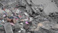 A boy sits among the rubble and scattered belongings of the Palestinian al-Atrash family, after their home was destroyed in an Israeli strike in Deir el-Balah in the central Gaza Strip on March 13, 2024, amid the ongoing conflict between Israel and the Palestinian Hamas group. (Photo by AFP)
