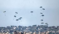 This picture taken from Israel's southern border with the Gaza Strip shows humanitarian aid being airdropped over the Palestinian territory on March 13, 2024. (Photo by Jack Guez / AFP)