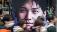 People walk past an advertisement with a picture of Shohei Ohtani in Tokyo on March 17, 2024. (Photo by Yuichi YAMAZAKI / AFP)