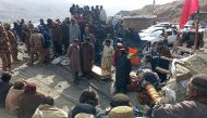 This handout photograph taken on March 20, 2024 and released by pakistan Mines and Minerals Development Department Balochistan shows miners gathered outside a collapsed mine as rescue personnel conduct a search operation for trapped workers in the mining region of Khost at Harnai district, Balochistan province. (Photo by MINES AND MINERALS DEVELOPMENT DEPARTMENT BALOCHISTAN / AFP) 
