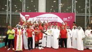 Al Arabi players and officials celebrate as they receive the champions' trophy.