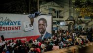 People gather outside anti-establishment candidate Bassirou Diomaye Faye's headquarters in Dakar on March 24, 2024 as results remain expected during the Senegalese presidential elections. (Photo by Carmen Abd Ali / AFP)
