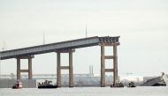 One remaining end of the Francis Scott Key Bridge stands in the water after the bridge collapsed when the cargo ship Dali ran into and collapsed it on March 26, 2024 in Baltimore, Maryland. (Photo by Kevin Dietsch / GETTY IMAGES NORTH AMERICA / Getty Images via AFP)
