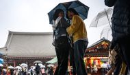 People walk with their umbrellas during a rainy day at Sensoji Temple, a popular tourist location, in Tokyo's Asakusa district on March 26, 2024. (Photo by Philip FONG / AFP)