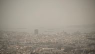 This photo taken on March 27, 2024 shows the city of Athens shrouded in haze as persistent southerly winds have carried waves of dust from the African continent across the eastern Mediterranean. (Photo by Angelos TZORTZINIS / AFP)
