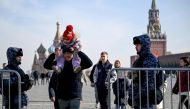 People walk past Russian law enforcement officers standing guard at the Red Square in Moscow on March 29, 2024. Photo by NATALIA KOLESNIKOVA / AFP.
